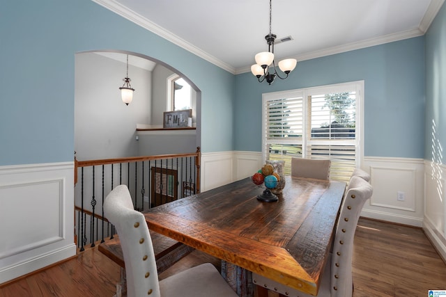 dining area featuring ornamental molding, an inviting chandelier, dark wood-type flooring, and a wealth of natural light