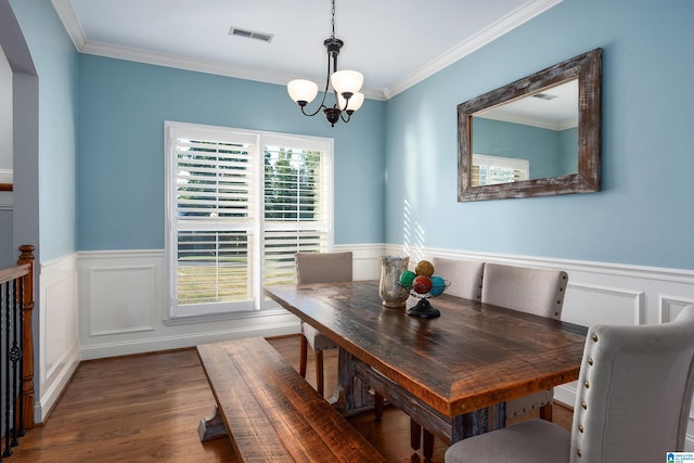 dining room with an inviting chandelier, dark hardwood / wood-style floors, ornamental molding, and a wealth of natural light