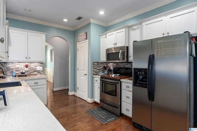 kitchen featuring appliances with stainless steel finishes, decorative backsplash, dark hardwood / wood-style flooring, and white cabinets