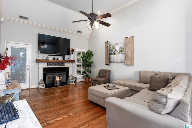 living room featuring wood-type flooring, ornamental molding, high vaulted ceiling, and ceiling fan