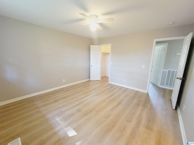 unfurnished bedroom with visible vents, light wood-style flooring, ceiling fan, and baseboards