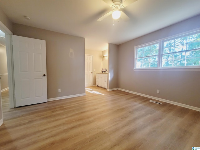 unfurnished bedroom with light wood finished floors, visible vents, and baseboards