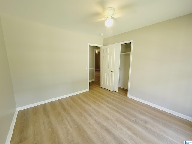 unfurnished bedroom featuring ceiling fan, a closet, and light hardwood / wood-style flooring