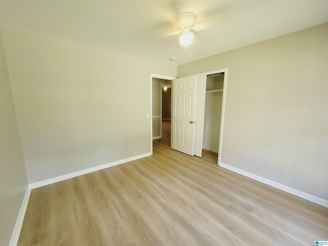 unfurnished bedroom with light wood-type flooring, a closet, ceiling fan, and baseboards