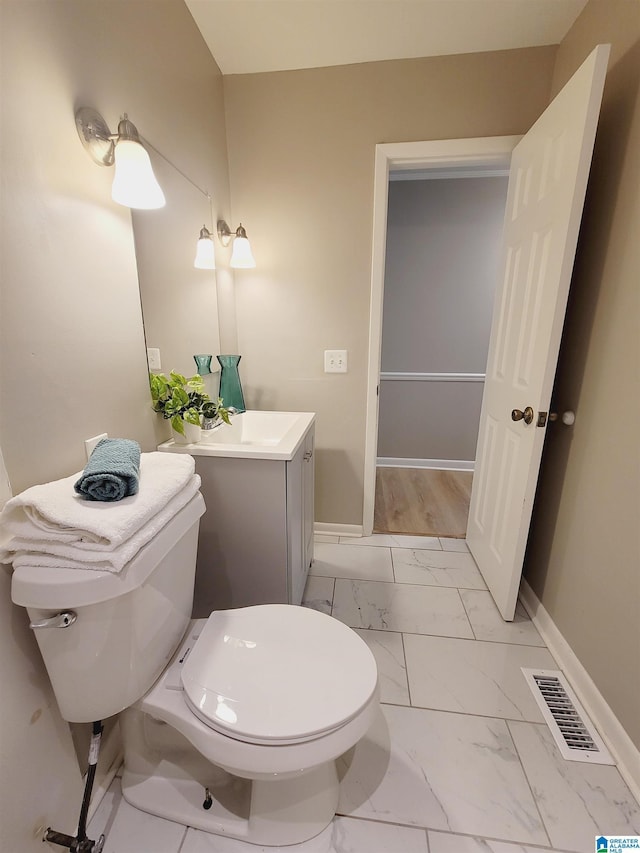 bathroom with toilet, visible vents, baseboards, and marble finish floor