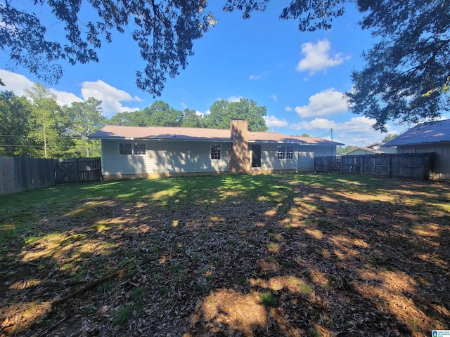 rear view of property with a yard and a fenced backyard