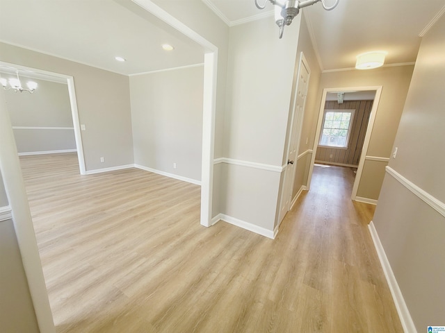 hallway with ornamental molding, a chandelier, and light hardwood / wood-style floors