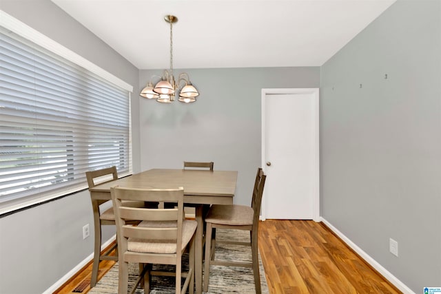 dining space with an inviting chandelier and light wood-type flooring