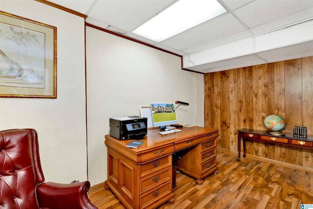 office with a drop ceiling, wood-type flooring, and wood walls