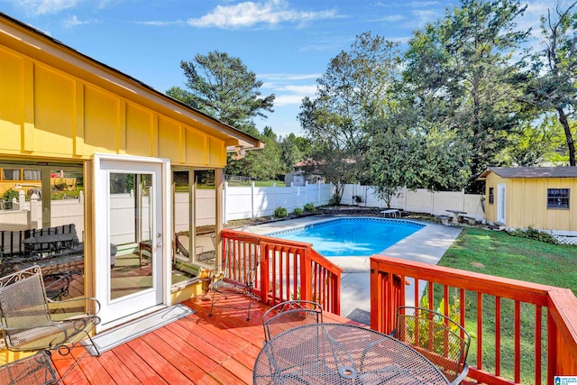 view of pool featuring a storage shed, a deck, and a yard