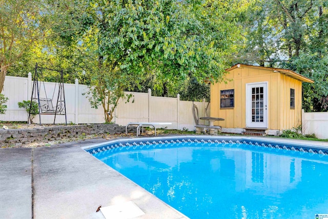 view of swimming pool with a patio area and an outbuilding