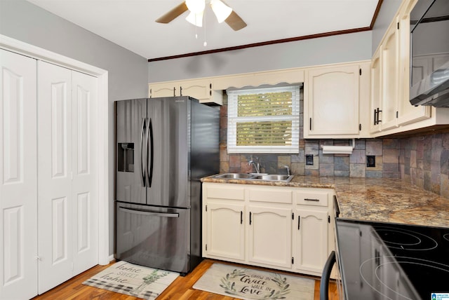 kitchen featuring light stone counters, appliances with stainless steel finishes, light wood-type flooring, and sink