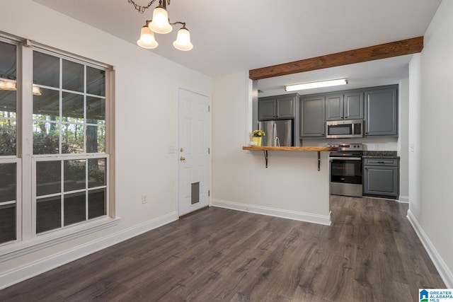 kitchen featuring wooden counters, dark wood-type flooring, appliances with stainless steel finishes, beam ceiling, and decorative light fixtures