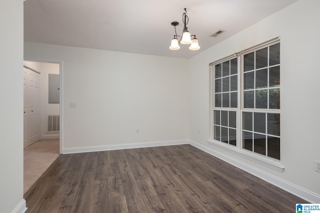 unfurnished room featuring a notable chandelier and dark hardwood / wood-style floors