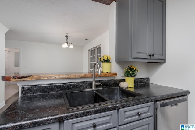 kitchen featuring a notable chandelier, gray cabinets, sink, and stainless steel dishwasher