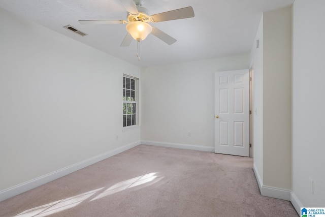 carpeted spare room featuring ceiling fan