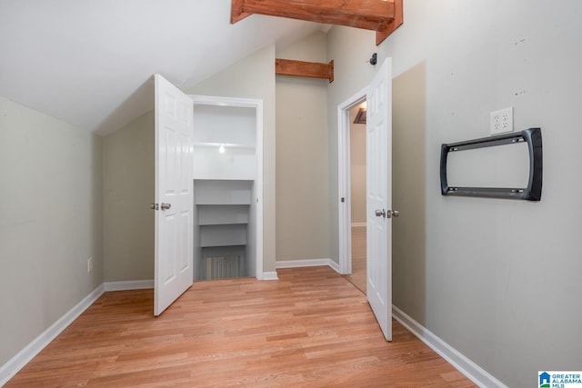 hall featuring lofted ceiling and light hardwood / wood-style flooring