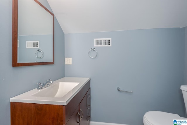 bathroom with vaulted ceiling, vanity, and toilet