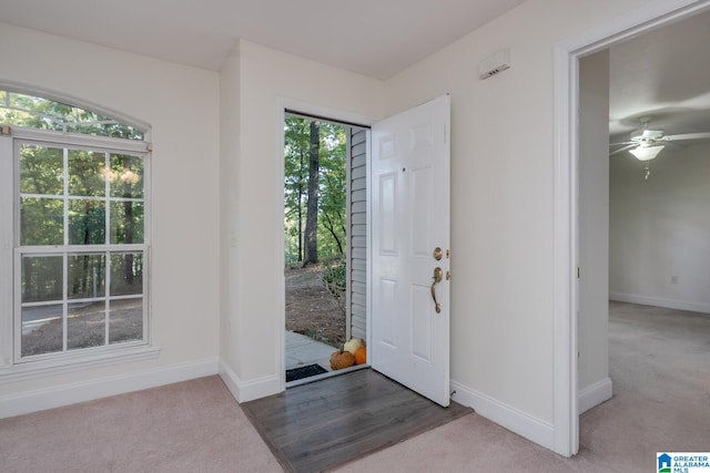 carpeted foyer entrance with ceiling fan