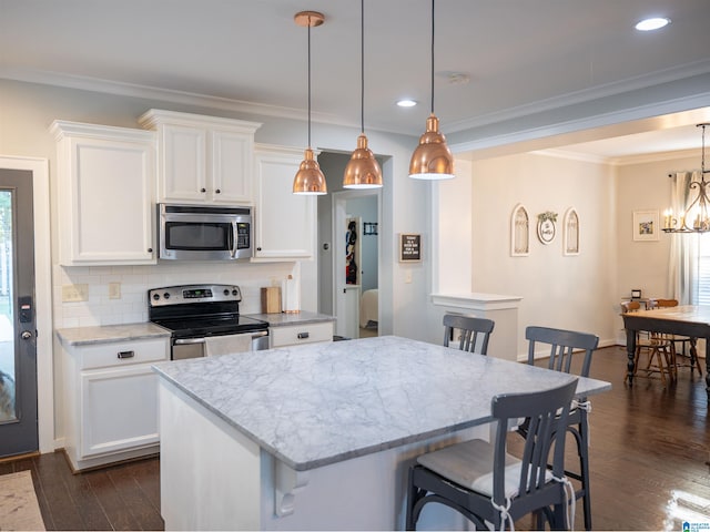 kitchen with white cabinets, stainless steel appliances, and hanging light fixtures