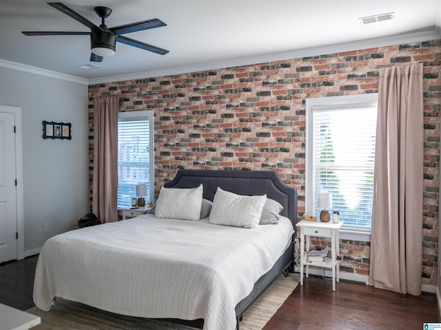 bedroom with dark hardwood / wood-style floors, brick wall, crown molding, and ceiling fan