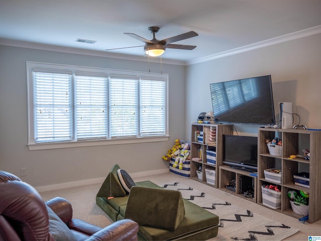 carpeted living room featuring ceiling fan, ornamental molding, and a healthy amount of sunlight