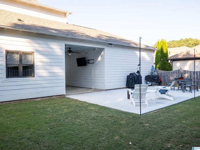 rear view of property featuring a lawn, a patio area, and ceiling fan