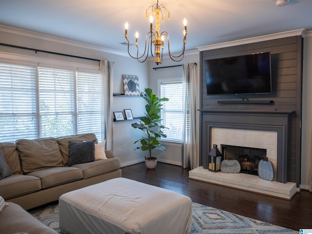 living room featuring a fireplace, crown molding, dark wood-type flooring, and a chandelier