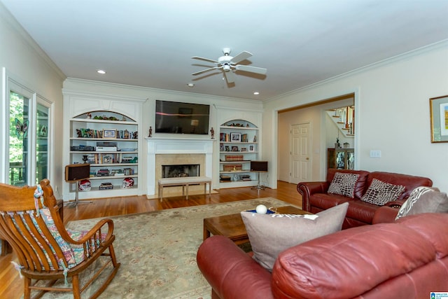 living room featuring ornamental molding, built in features, and wood-type flooring