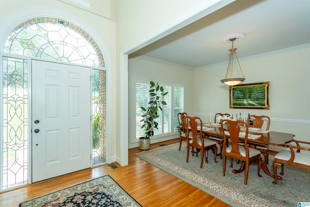 foyer with ornamental molding and light hardwood / wood-style flooring