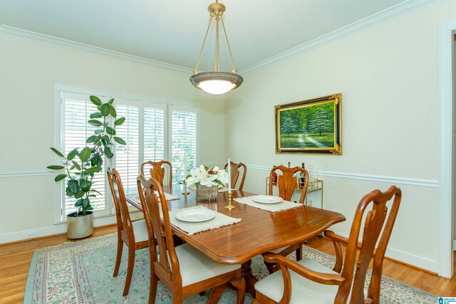 dining space with ornamental molding and hardwood / wood-style floors