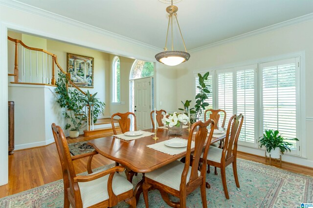 dining room with hardwood / wood-style flooring, a healthy amount of sunlight, and crown molding