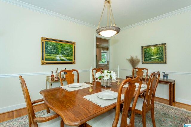 dining area with wood-type flooring and crown molding