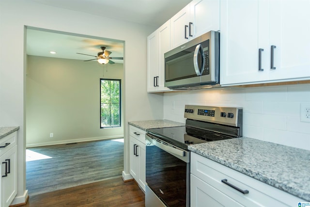 kitchen featuring light stone counters, stainless steel appliances, dark hardwood / wood-style flooring, and white cabinetry