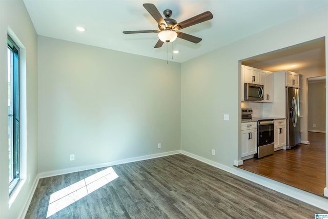 unfurnished living room with ceiling fan, dark hardwood / wood-style floors, and a healthy amount of sunlight