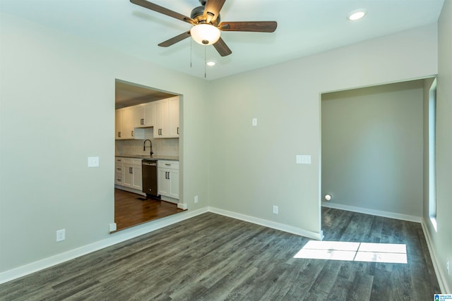 empty room featuring ceiling fan, sink, and dark hardwood / wood-style flooring