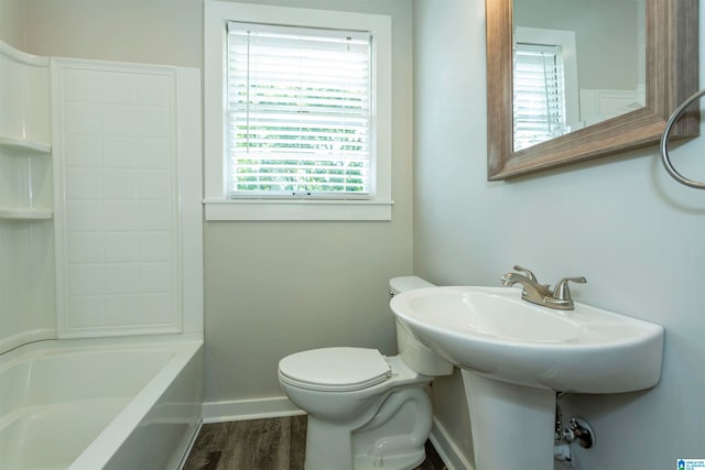 bathroom featuring wood-type flooring, shower / bathing tub combination, plenty of natural light, and toilet