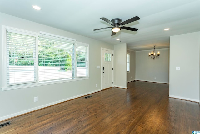 unfurnished room with ceiling fan with notable chandelier and dark hardwood / wood-style flooring