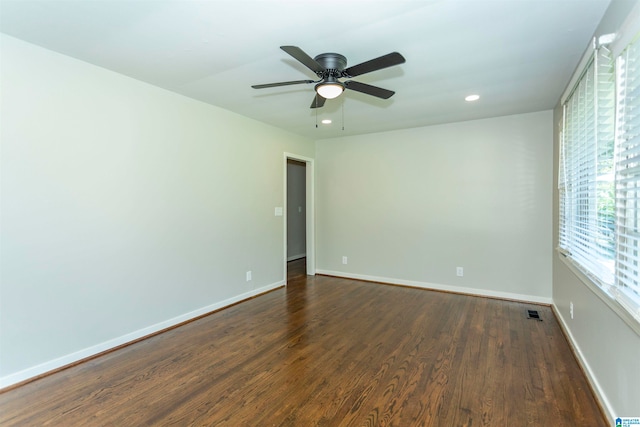 empty room with dark hardwood / wood-style floors and ceiling fan