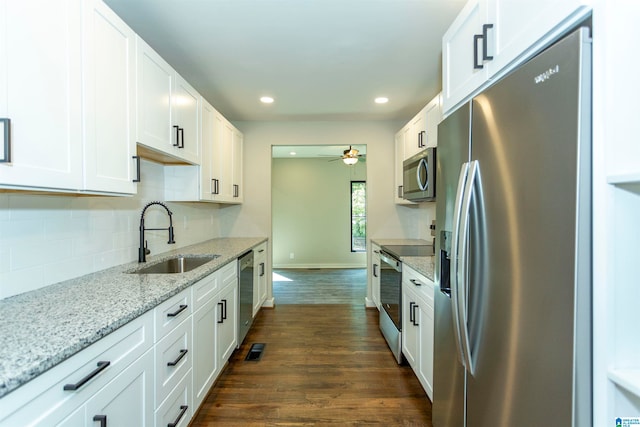 kitchen with light stone countertops, dark hardwood / wood-style floors, stainless steel appliances, sink, and white cabinetry