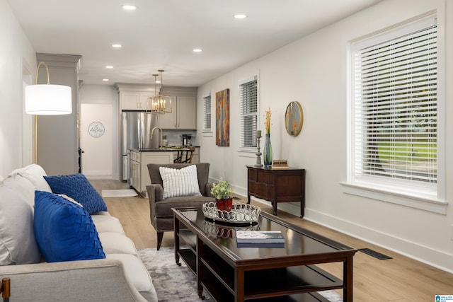 living room featuring light hardwood / wood-style floors and a chandelier