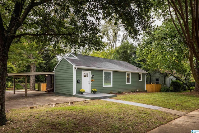 view of front of property featuring a front lawn and a carport