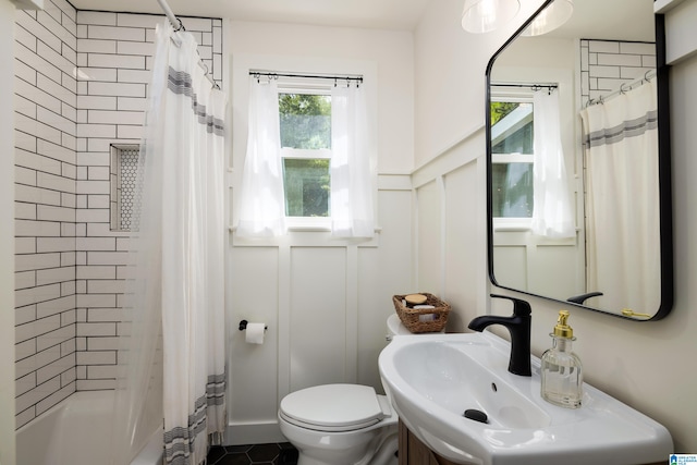 full bathroom featuring shower / bath combination with curtain, sink, and toilet