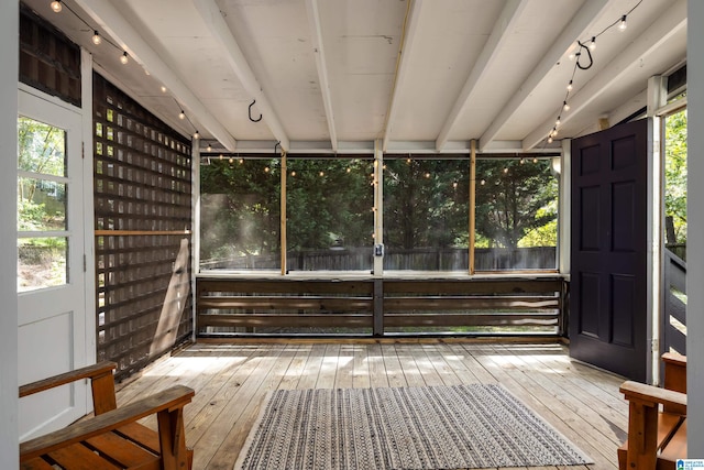 unfurnished sunroom with beamed ceiling