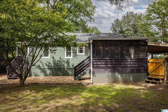 back of property with a sunroom and a yard