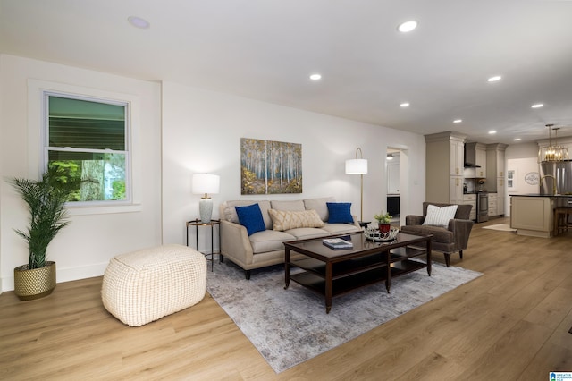 living room featuring a notable chandelier and light hardwood / wood-style flooring