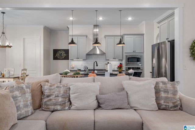 living room with crown molding, sink, and an inviting chandelier