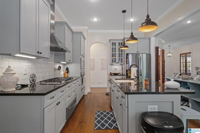 kitchen with pendant lighting, sink, stainless steel appliances, dark hardwood / wood-style floors, and a breakfast bar area