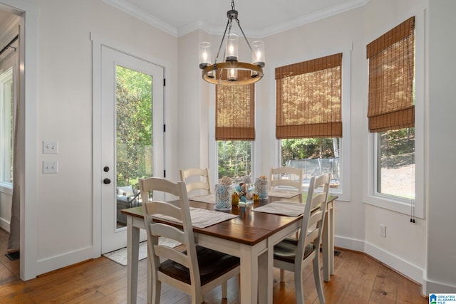 dining room with ornamental molding, a chandelier, and light hardwood / wood-style flooring