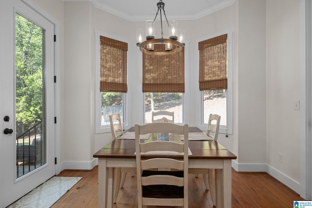 dining room featuring light wood-type flooring, a chandelier, and ornamental molding